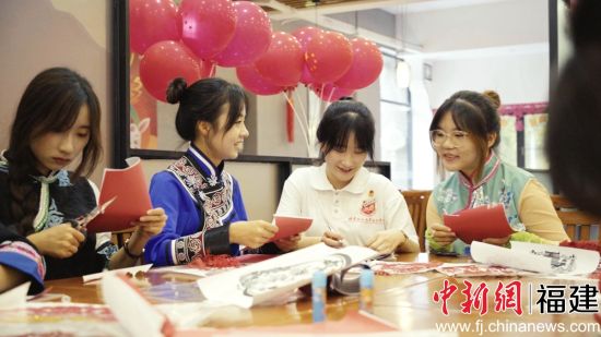 圖為少數(shù)民族學(xué)生包月餅共度中秋佳節(jié)。