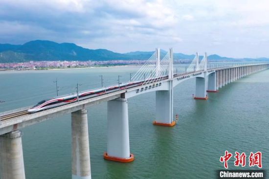 9月28日，復興號智能動車組行駛在福廈高鐵湄洲灣跨海大橋。歷經(jīng)6年多時間建設，全長277公里的福廈高鐵，穿越多處山脈，跨越多處海灣，將難上九重天的閩道與大海緊緊相連。李響攝